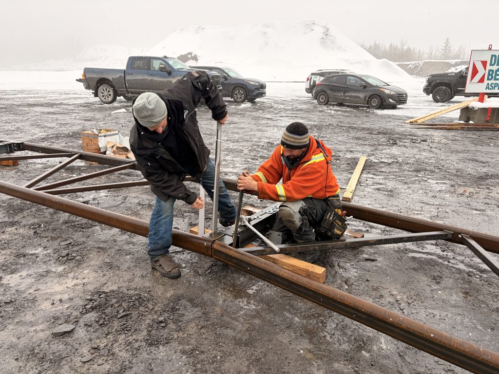 Two men working on the new arch for the wide span building (100 series by MegaDome)